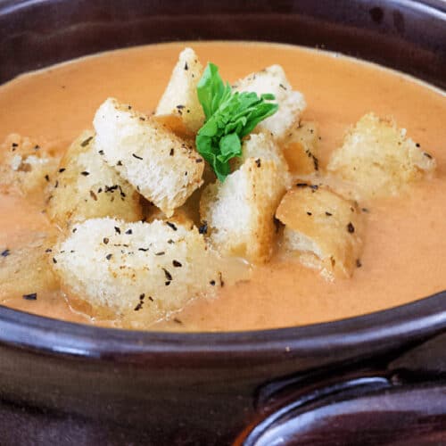 Creamy tomato soup in a bowl with croutons.