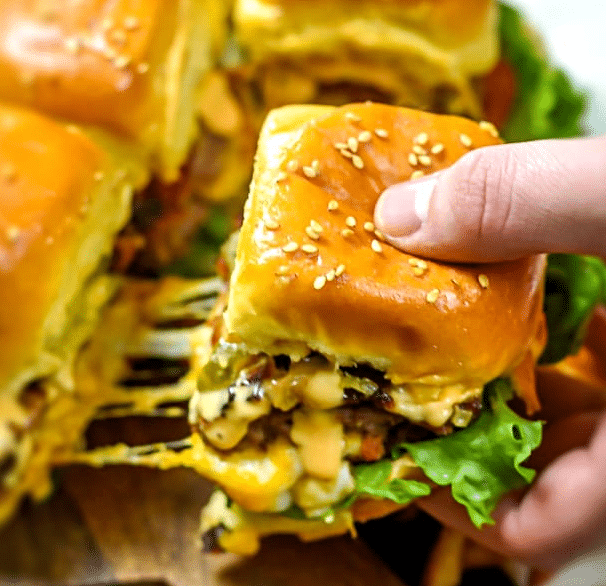 Hand holding a juicy lucy slider.