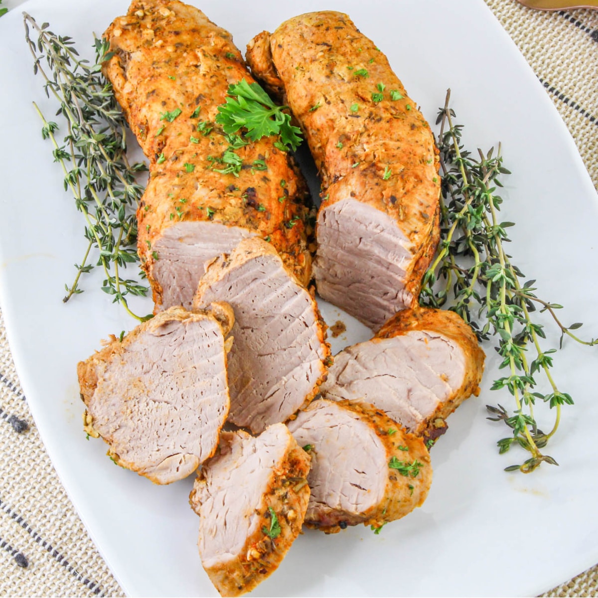 Dutch Oven Roasted Pork Tenderloin on a plate with fresh thyme.