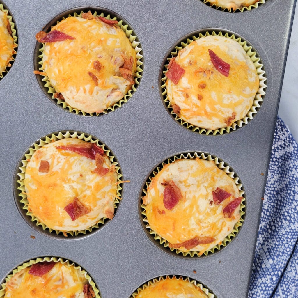 Close up of cheddar and bacon muffins in a baking pan.