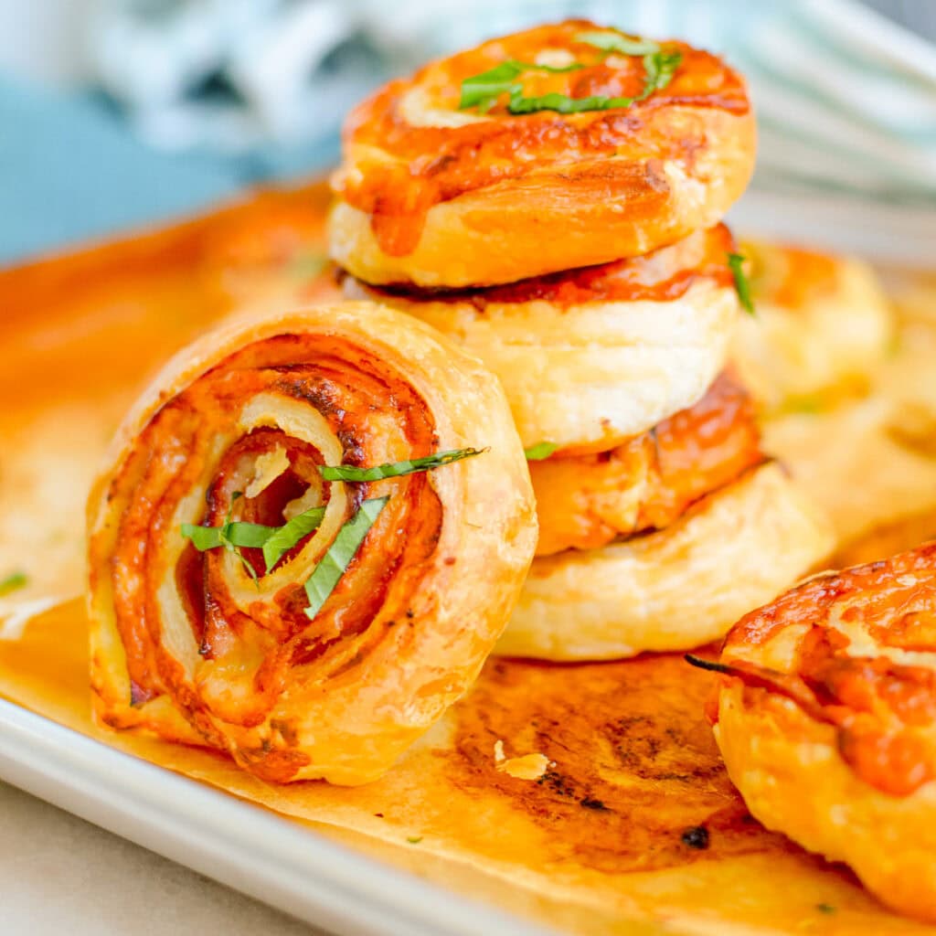 Ham and Cheese Puff Pastry: a stack of golden, flaky ham and cheese pinwheels with puff pastry.
