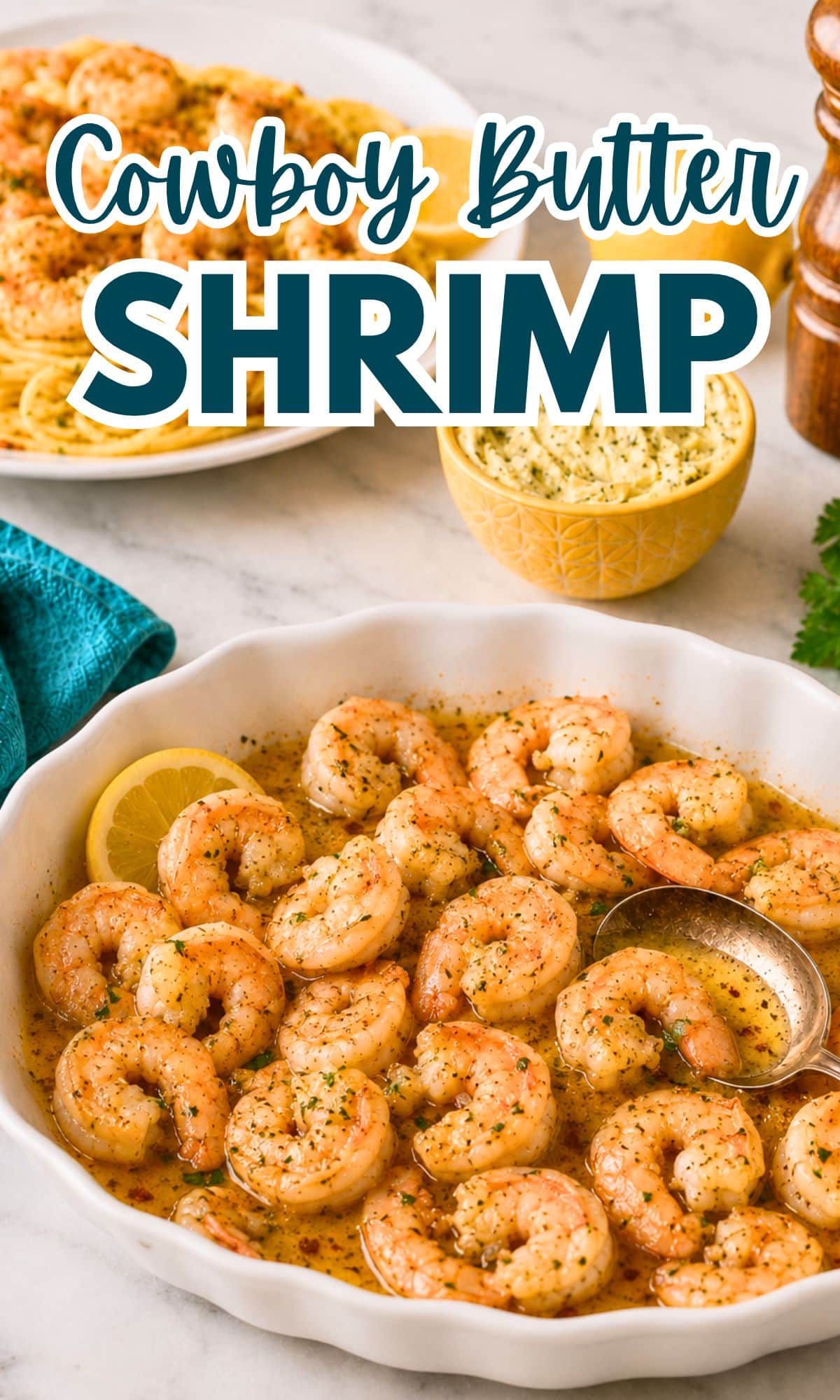 A white dish filled with Cowboy Butter Shrimp sits invitingly in a luscious, buttery sauce, garnished with herbs and a lemon slice. A spoon rests in the dish, with a bowl of extra butter and a plate of shrimp pasta visible in the background.
